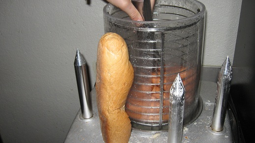 Impaled bread, with hotdogs behind.